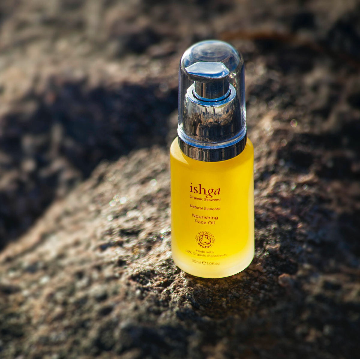 Glass bottle of ishga Nourishing Organic Face Oil on a rock