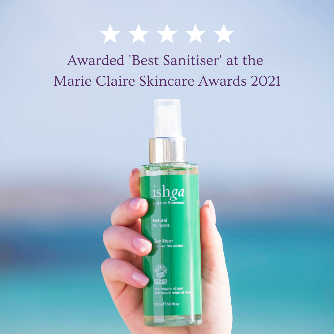 Hand holding a bottle of award winning ishga Hand Sanitiser