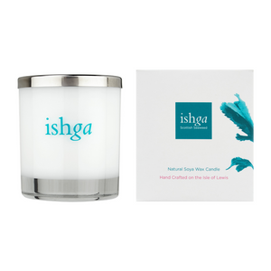 ishga Hebridean Dreams Candle opened with the flame lit, on top of a shelf